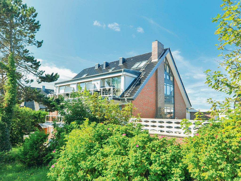 Windeby Wenningstedt – Haus mit Wintergartenfront und Balkonen hinter Dünenbewuchs