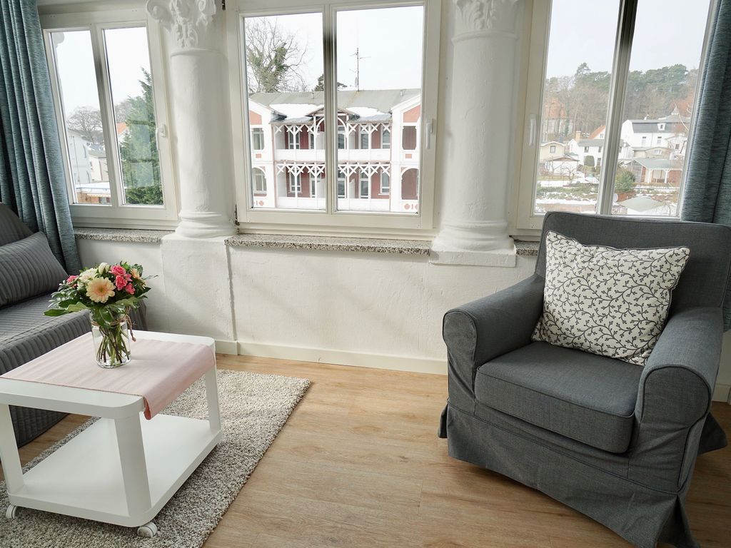 Haus Arkona Sellin – heller Wohnraum mit Sofa und Blick auf die Villen der Wilhelmstraße