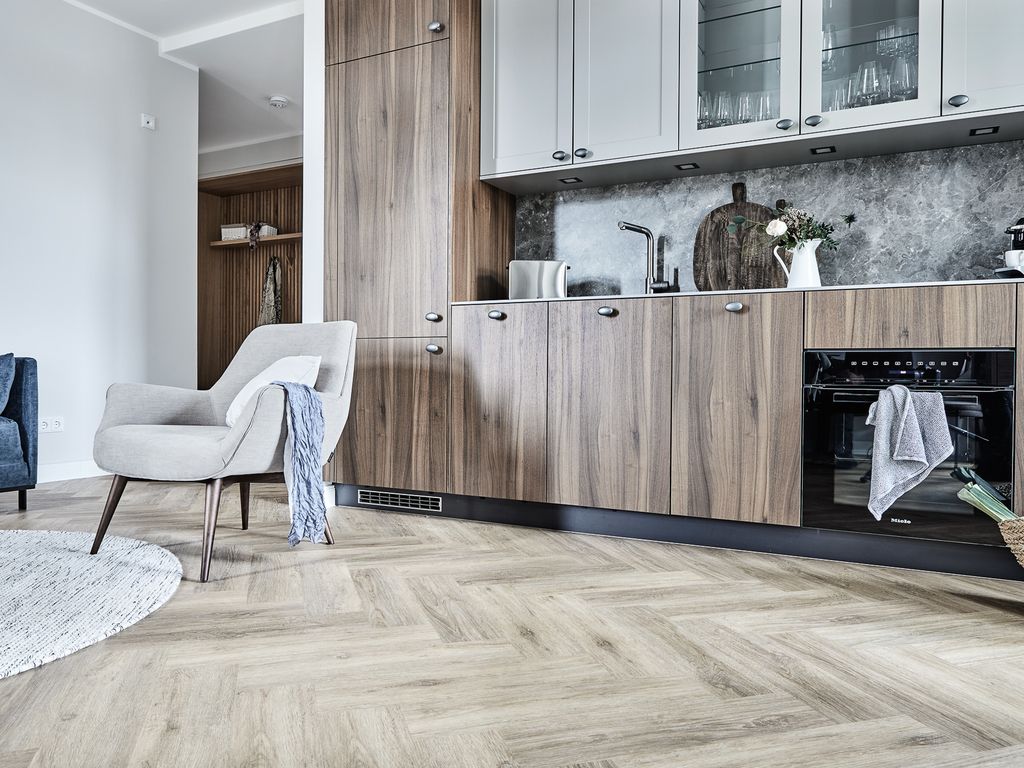 Villa Esperance Binz – Küche mit Holzfronten, Natursteinrückwand und Fischgrätboden