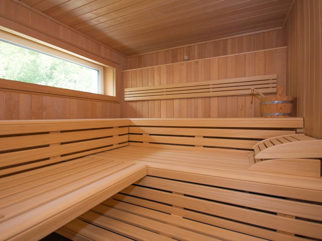 Haus Waldidyll Sellin – Sauna im Haus mit Holzbänken und Fenster zum Wald