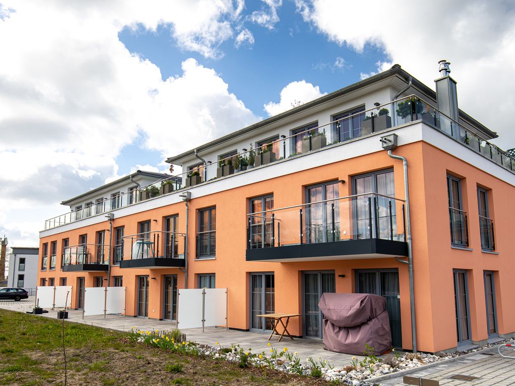 Alte Fischfabrik Lauterbach – moderner lachsfarbener Apartmentbau mit Balkonen und Dachterrassen