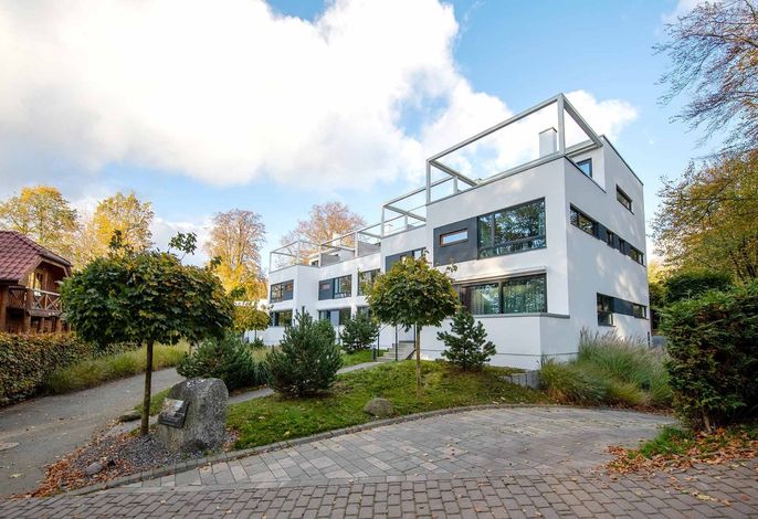 Strandhäuser & Strandvillen Sellin – weiße kubische Bauhaus-Fassade mit Dachterrassen im Grünen