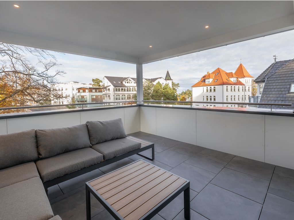 Villa Beatrice Binz – überdachte Loggia mit Loungemöbeln und Blick auf die Binzer Bädervillen