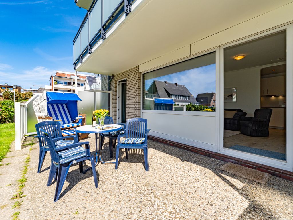 Dr.-Roß-Straße 25 Westerland – sonnige Terrasse mit blauem Strandkorb und Gartenmöbeln vor der Ferienwohnung