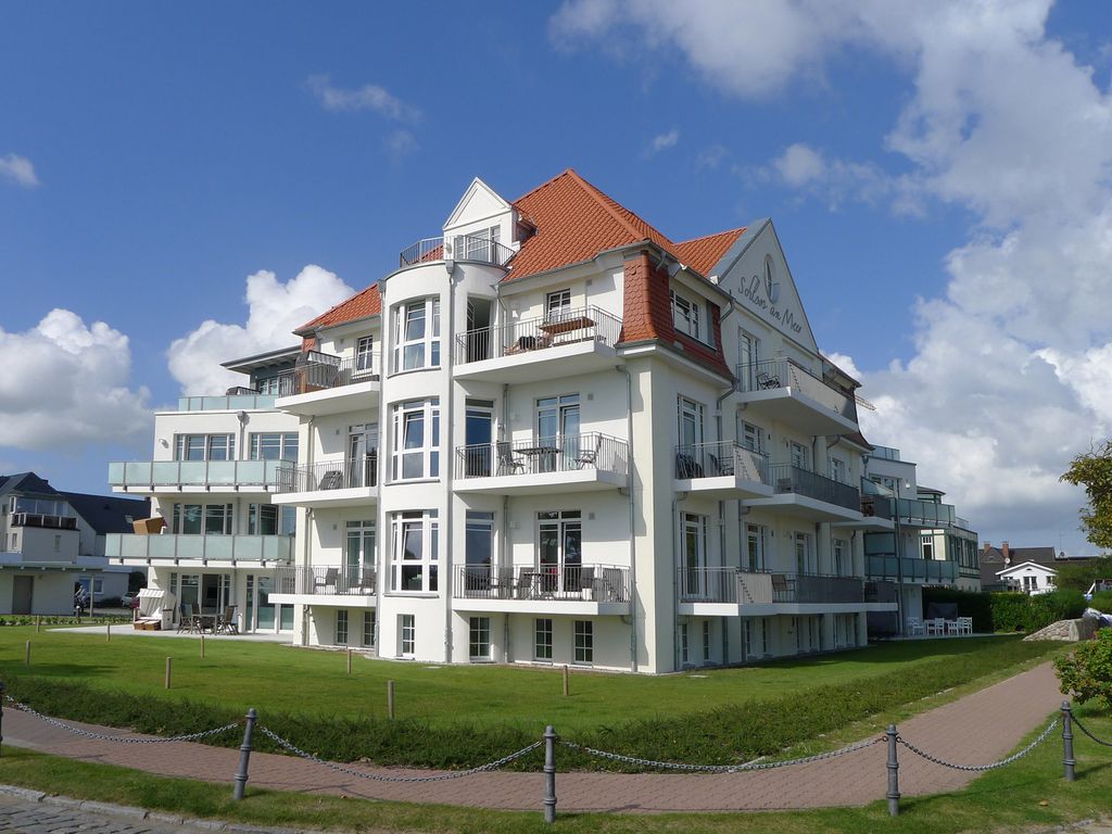 Schloss am Meer Wyk – weiße Villa mit rotem Walmdach, Balkonen und Rasenfläche
