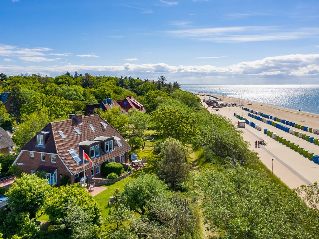 Haus Südstrand Wyk – Luftbild des reetnahen Hauses zwischen Grün, Strandpromenade und Wattenmeer