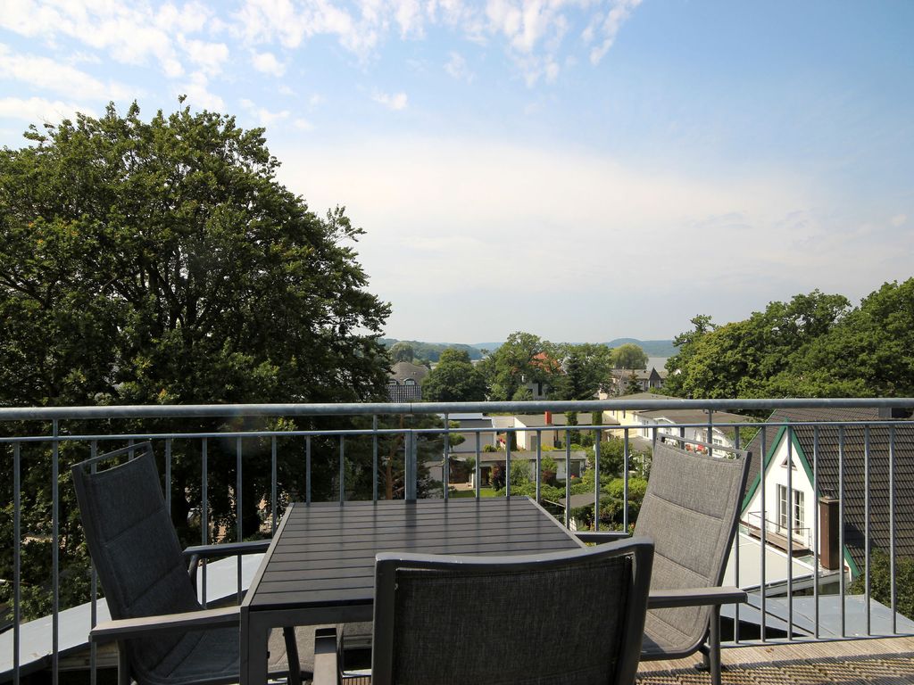 Altes Postamt Binz – möblierter Balkon mit Blick über Baumkronen und die Dächer von Binz