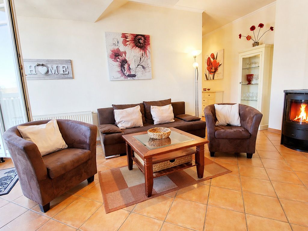 Villa Laetitia Binz – Wohnzimmer des Penthouses mit Kaminofen und Sesseln