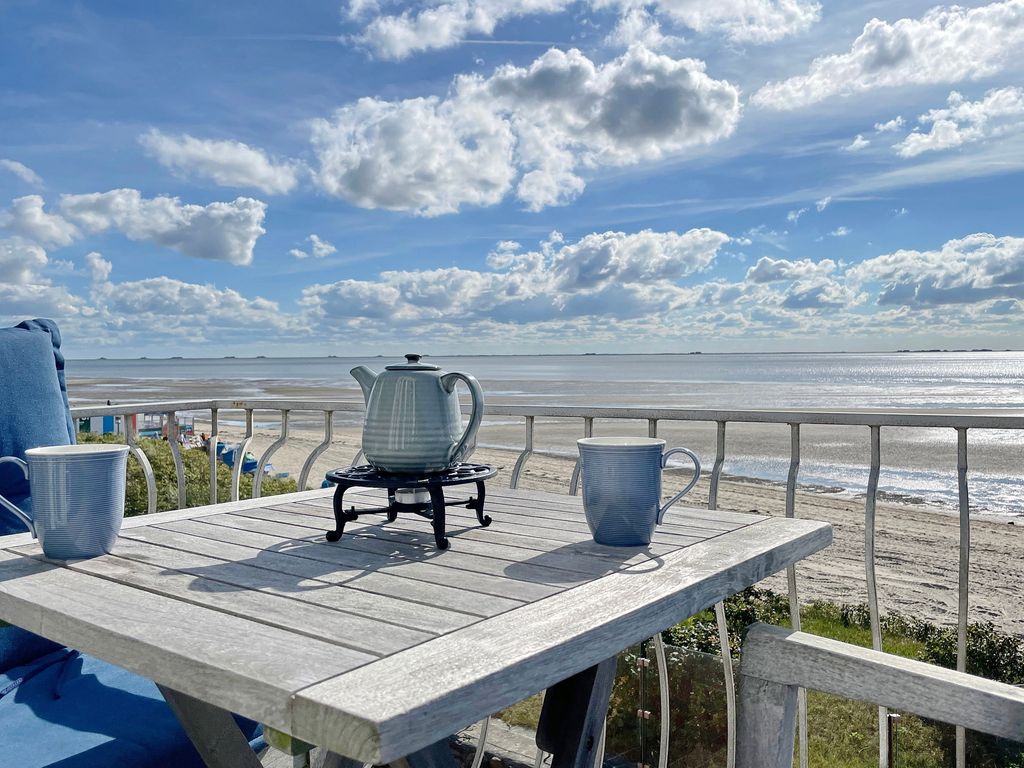 Huus Lüttenblick Wyk – gedeckter Tisch auf der Terrasse mit weitem Blick über Strand und Wattenmeer