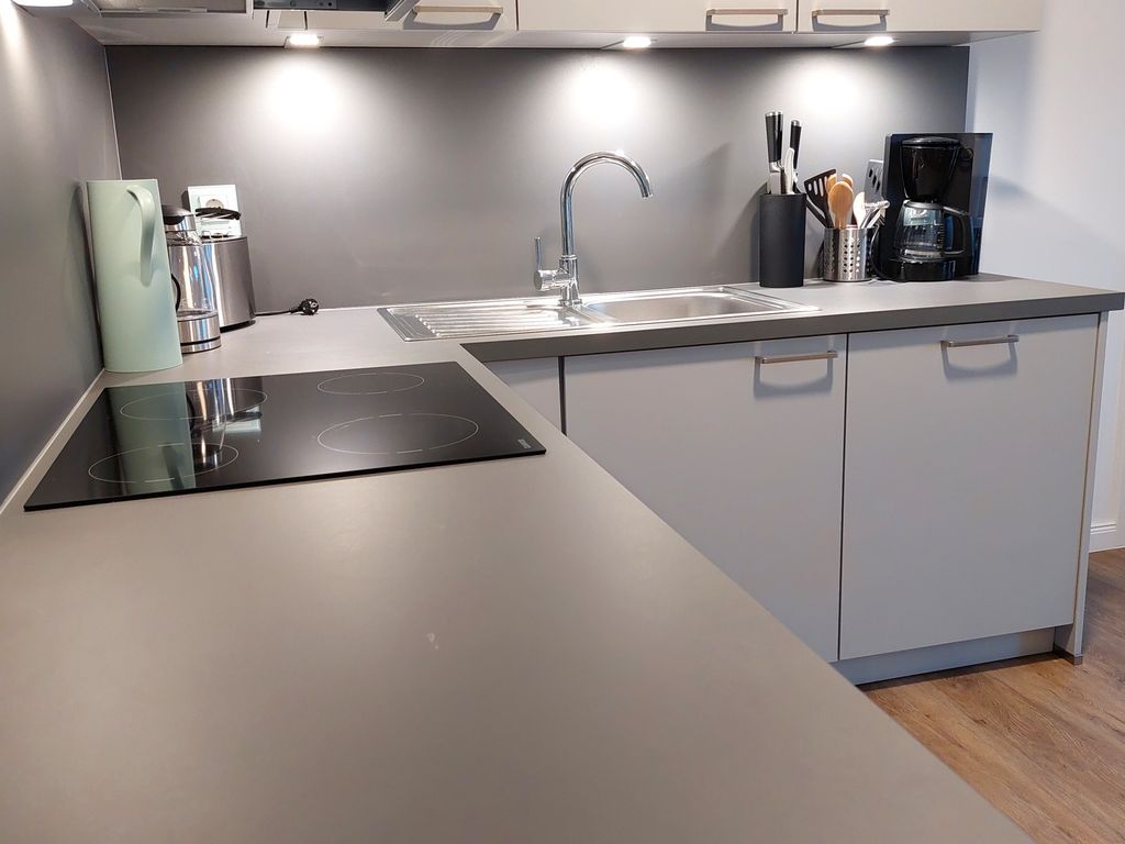 Haus Mönchgut Prora – offene weiße Einbauküche einer Ferienwohnung