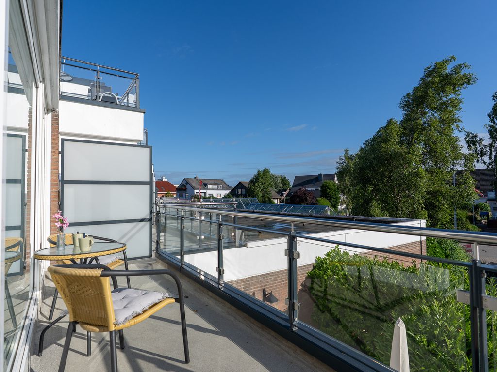 Haus Panorama Grömitz – Balkon mit Tisch und Stühlen, Blick über die Dächer des Ortes