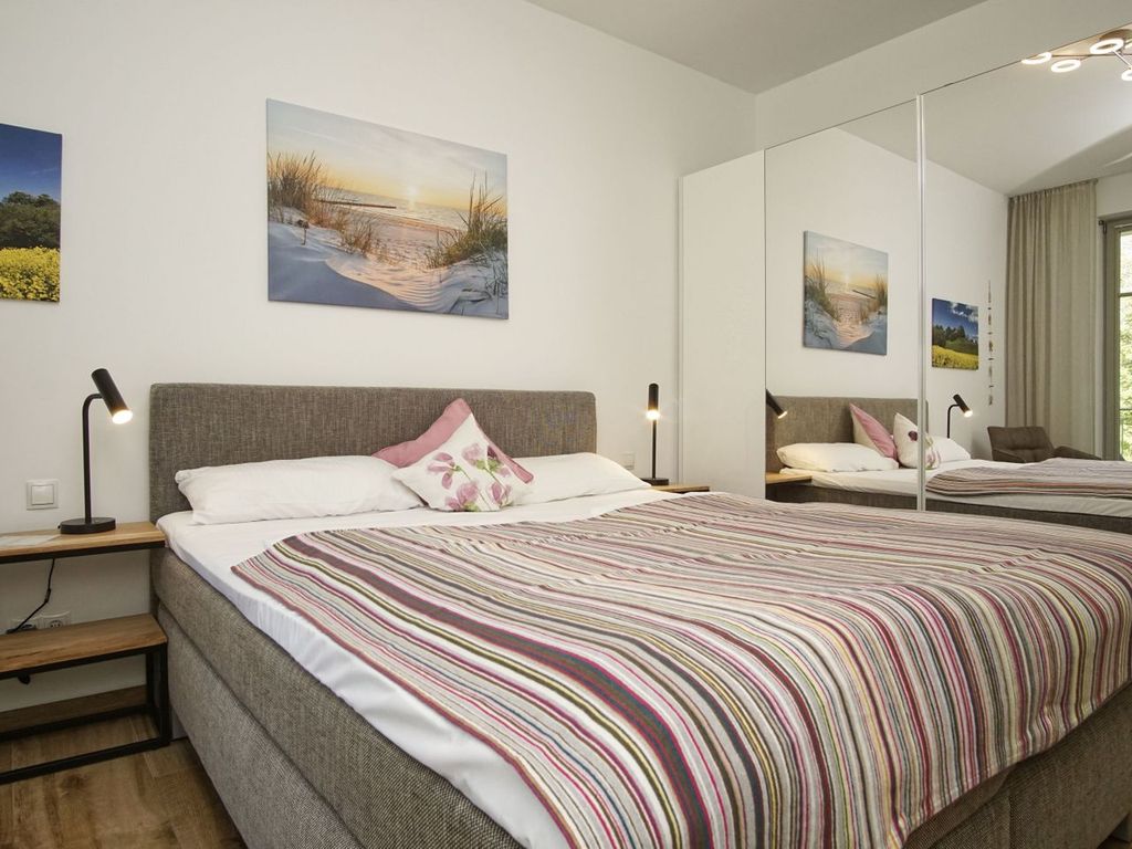 Villa Pauline Göhren – offene Küche mit Kochinsel und bodentiefen Fenstern zum Balkon