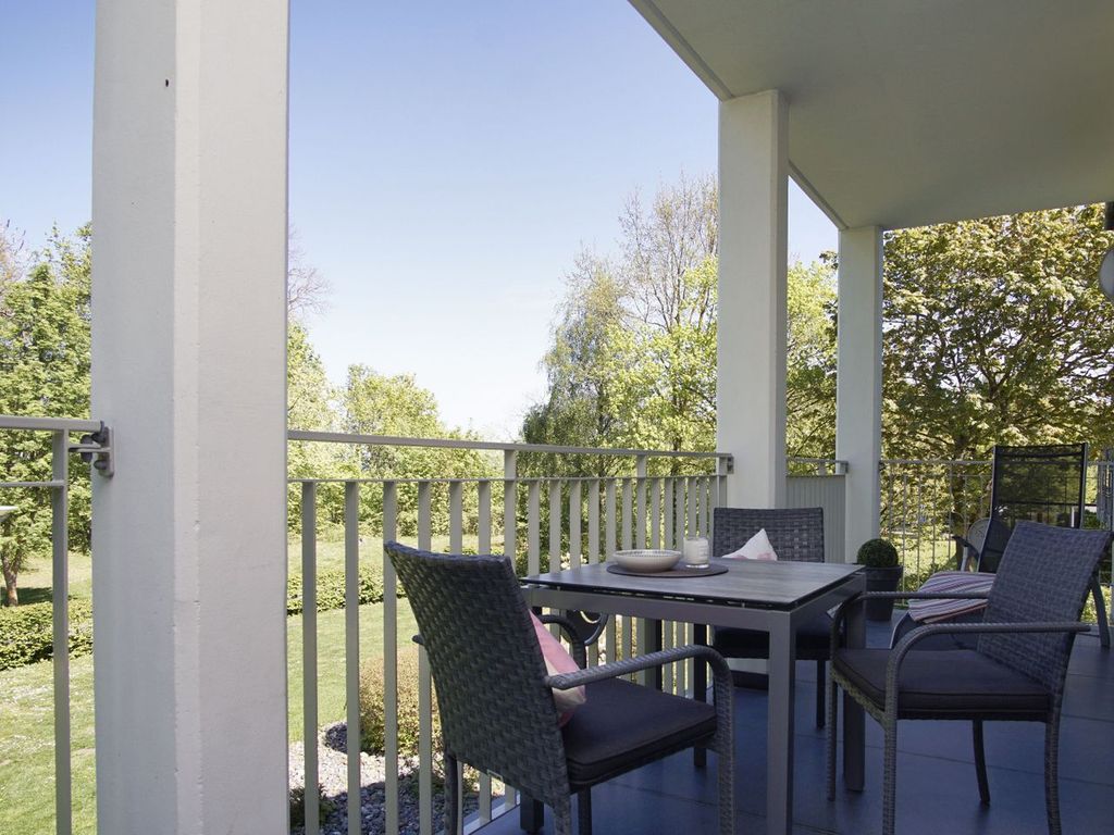 Villa Pauline Göhren – heller Wohnraum mit Polstermöbeln, blauen Akzenten und Massivholz-Couchtisch