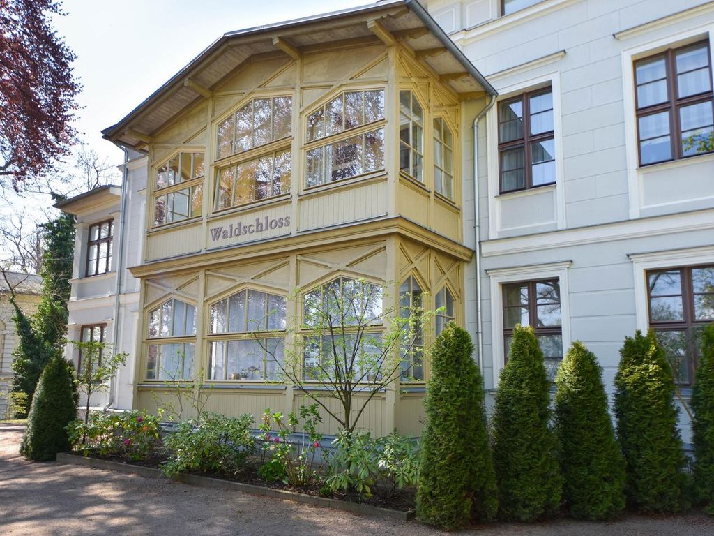 Villa Waldschloss Heringsdorf – hellgelber Holz-Erker mit Schriftzug „Waldschloss“ an der Hausfassade