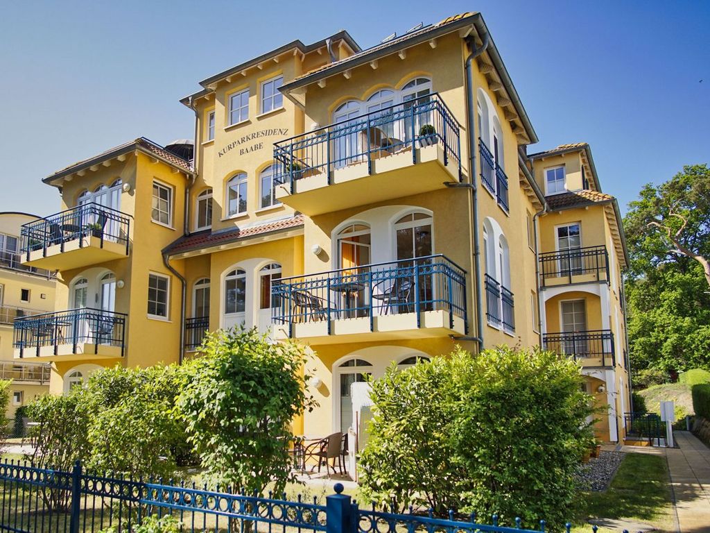 Kurparkresidenz Baabe – gelbe Bäderarchitektur-Villa mit Rundbogenfenstern und Balkonen