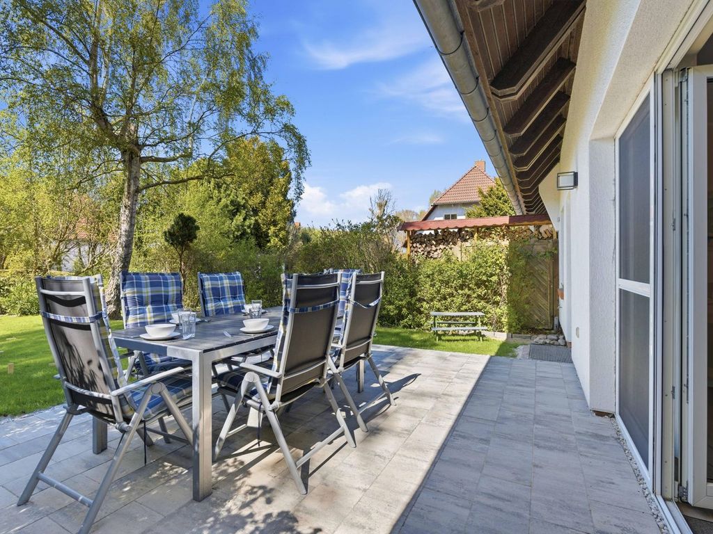 Terrasse mit Esstisch, Grill und Garten
