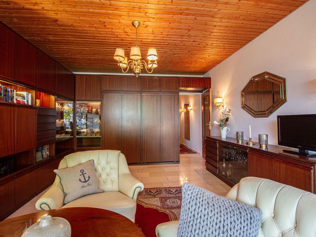 Ostsee Lodge – stilvoller Wohnbereich mit TV und gemütlichen Sesseln, Ferienwohnung am Strand von Brodau.