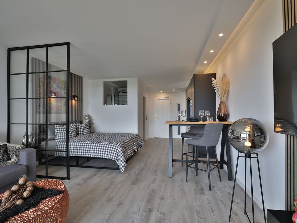 Strandkoje 7: Offenes Wohnkonzept mit Boxspringbett, Bartisch und stilvollem Industrial Design.