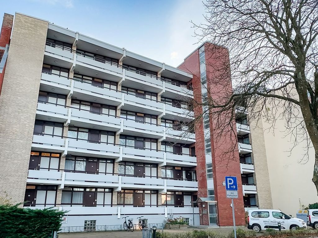 Haus Irma Wyk – mehrgeschossiges Apartmenthaus mit hellem Klinker, rotem Treppenturm und durchlaufenden Balkonreihen