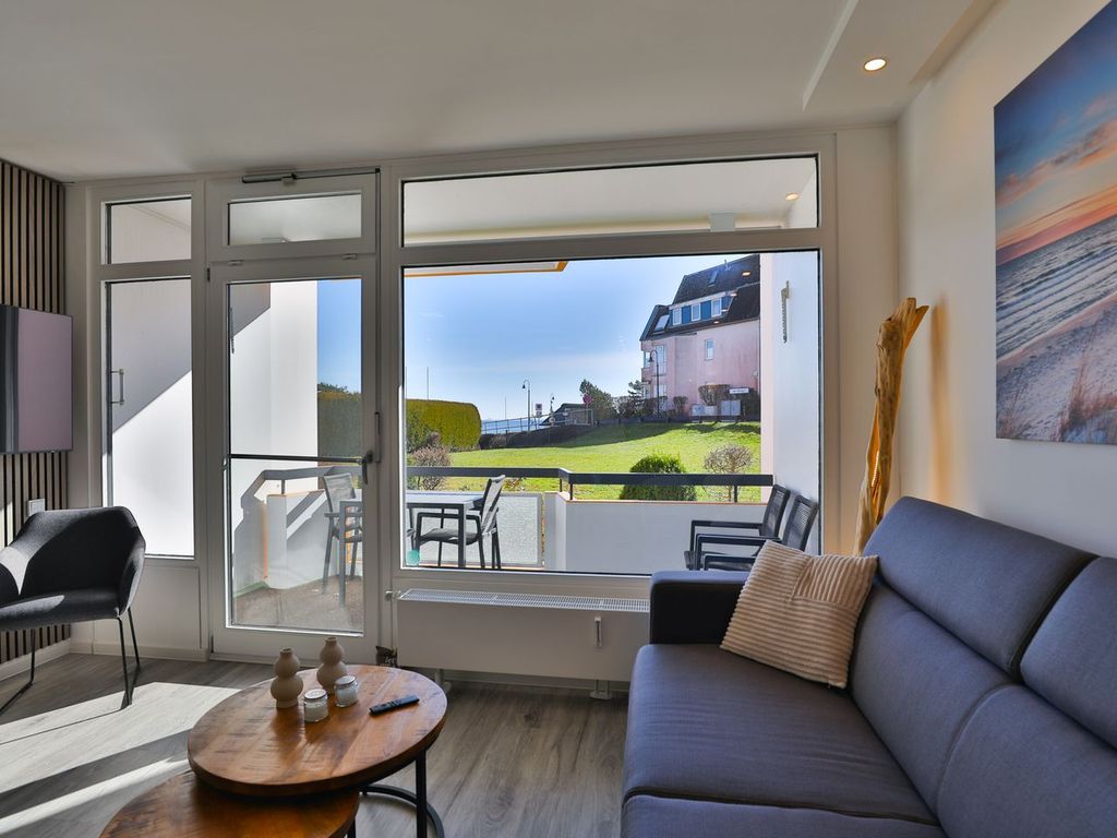 Strandkoje 104: Modernes Wohnzimmer mit Balkon und Teilmeerblick in Scharbeutz.