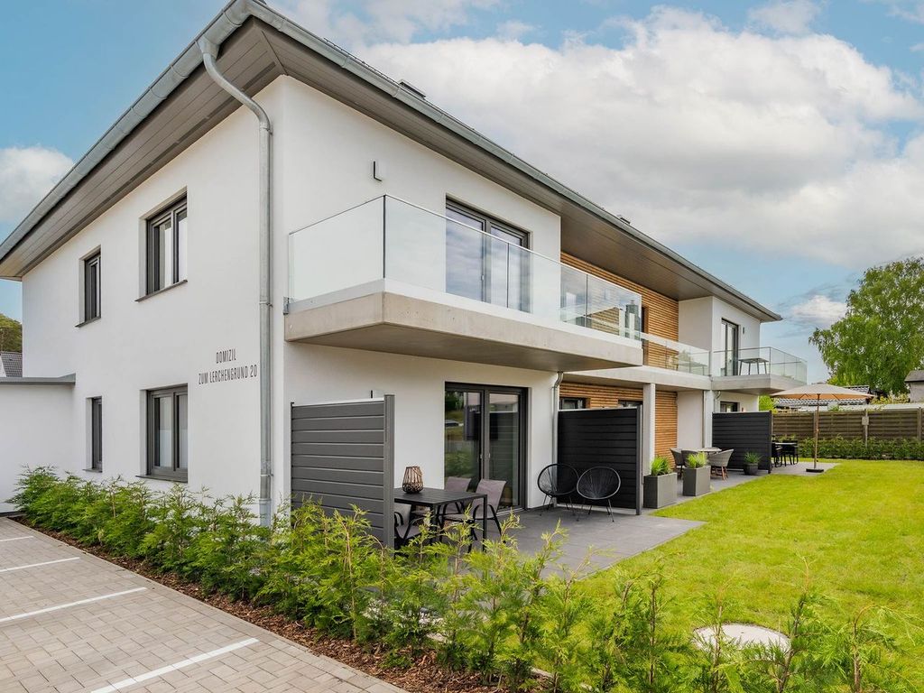 Domizil zum Lerchengrund Ückeritz – modernes weißes Ferienhaus mit Balkonen, Terrassen und Rasenfläche