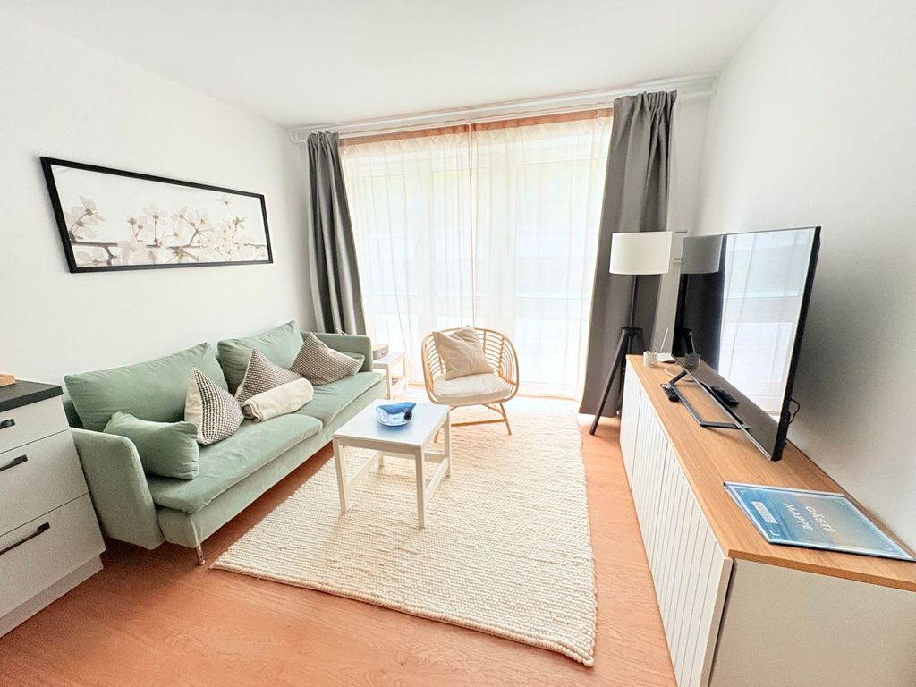 Stella Maris Binz – heller Wohnraum mit salbeigrünem Sofa und Tür zum Balkon