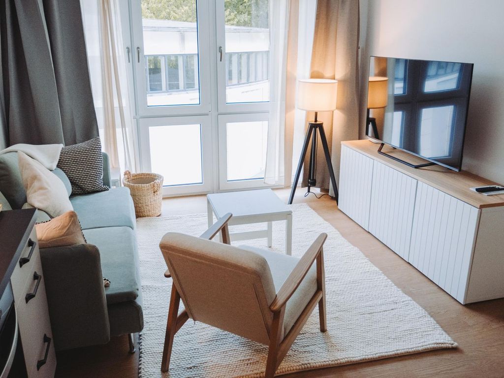 Stella Maris Binz – heller Wohnbereich im skandinavischen Stil mit salbeigrünem Sofa