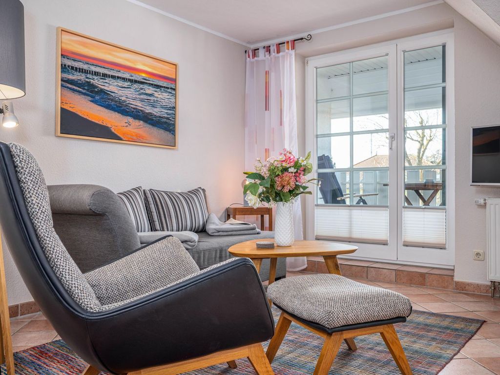 Wohnbereich mit Sofa, Sessel und TV
