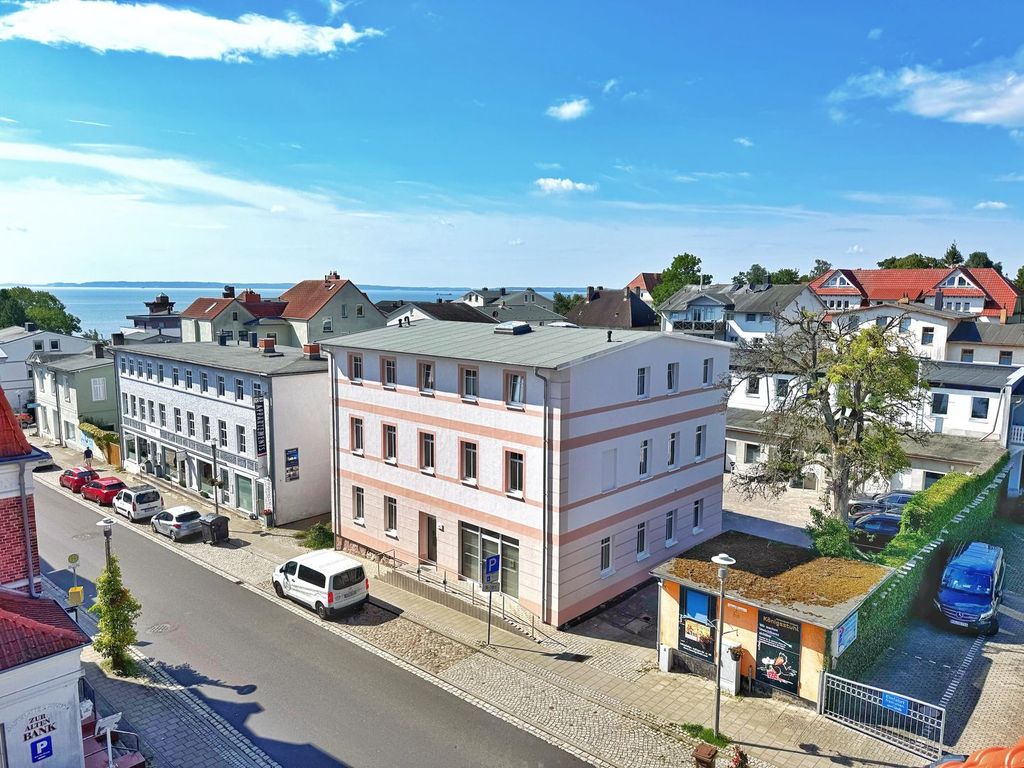 Haus Hafenmeister Sassnitz – saniertes Stadthaus in Weiß und Altrosa, im Hintergrund die Ostsee