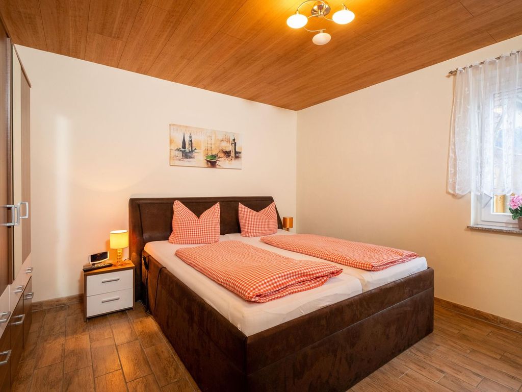 Schlafzimmer mit TV und Komfortbett, die motorisch in Kopf- und Fußteil verstellbar ist.