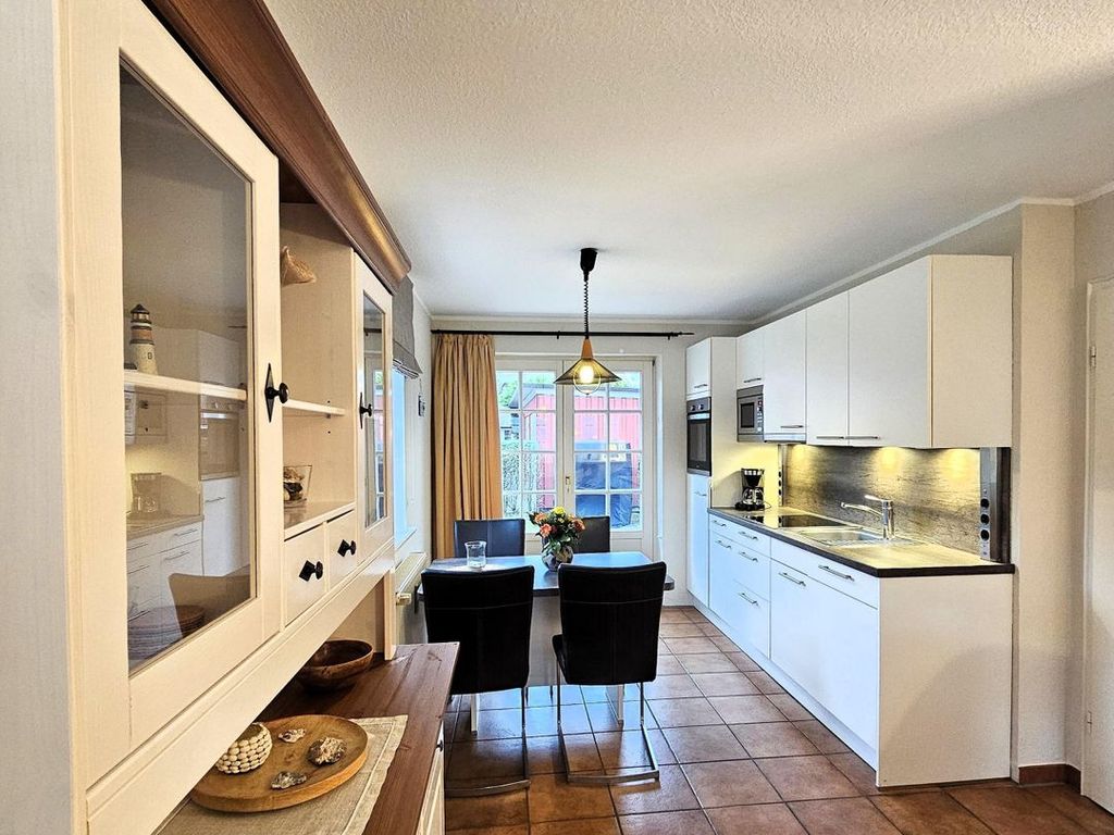 Moderne Küche mit Essbereich und Blick nach draußen.