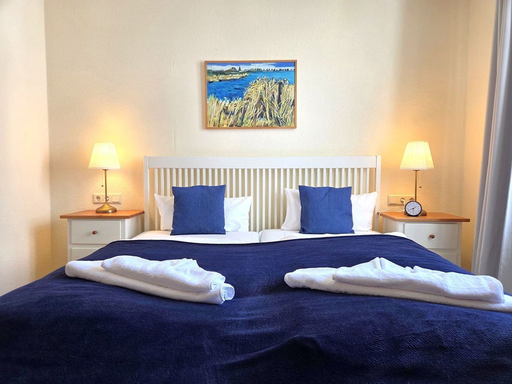 Villa Seeblick Sassnitz – heller Wohnbereich mit weißem Sofa, Holzboden und blau-weißen maritimen Akzenten