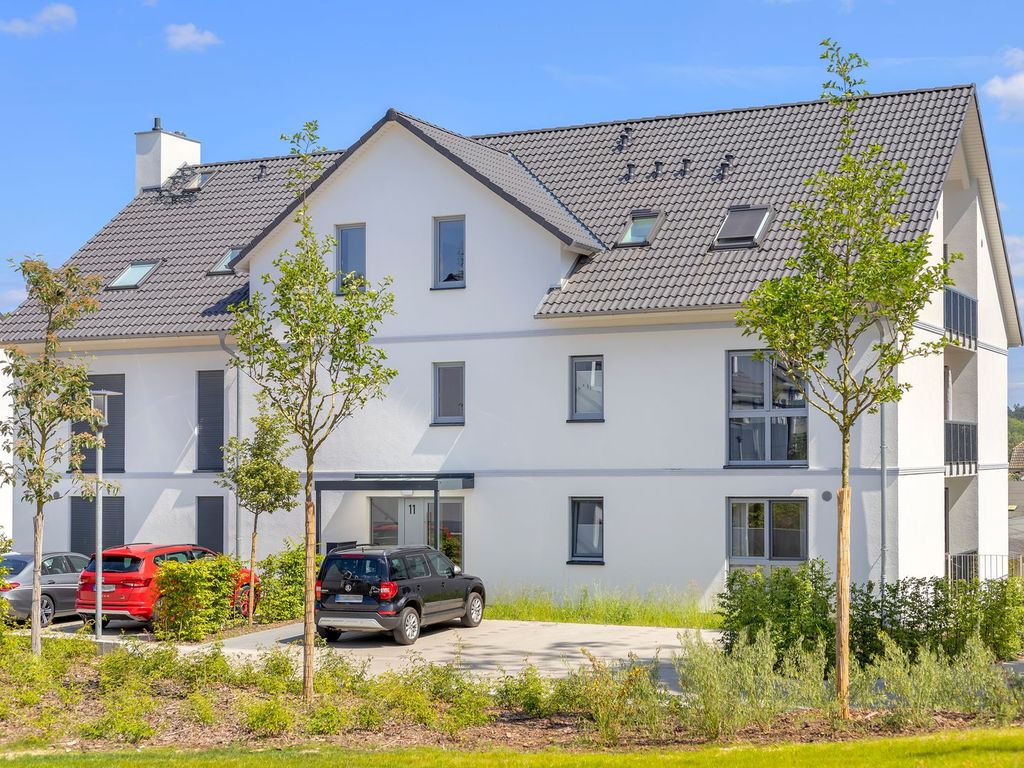 Bernsteinquartier Loddin – weißes Ferienhaus der Anlage mit dunklem Satteldach und Gauben