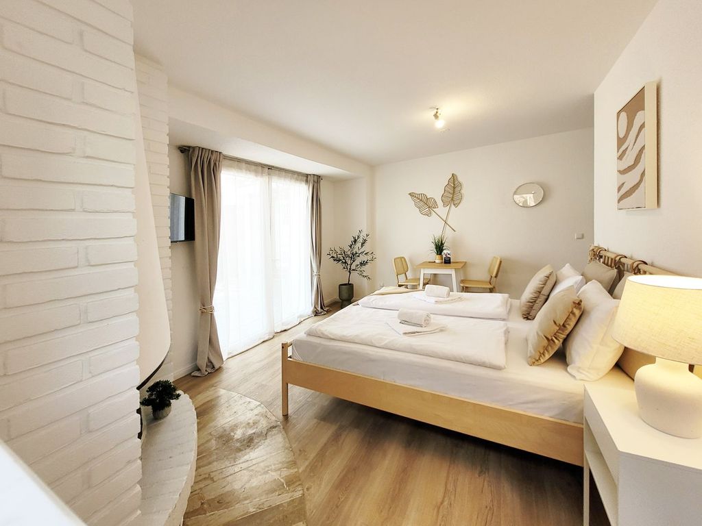 Ansicht Schlafzimmer mit Doppelbett und Smart TV