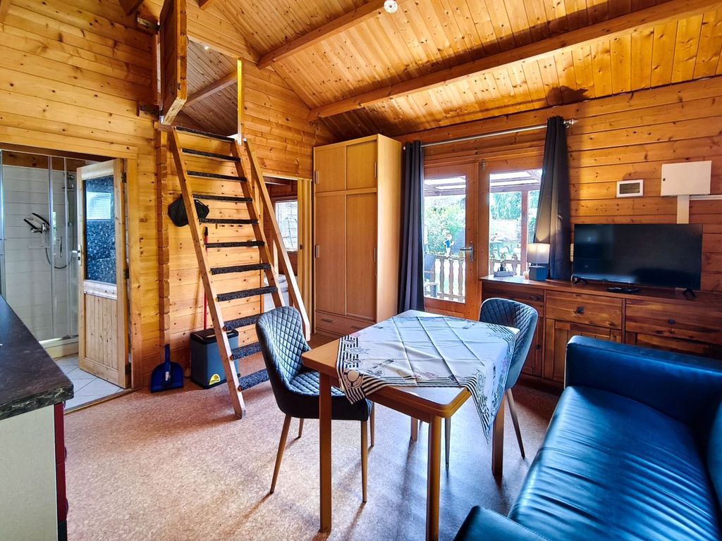 Gemütliches Wohnzimmer im rustikalen Holzblock-Stil des Ferienbungalows Seestern