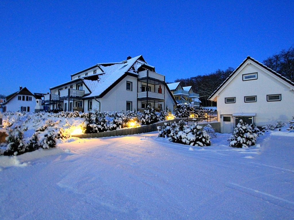Verschneite Außenanlage mit stimmungsvoller Abendbeleuchtung im Winter