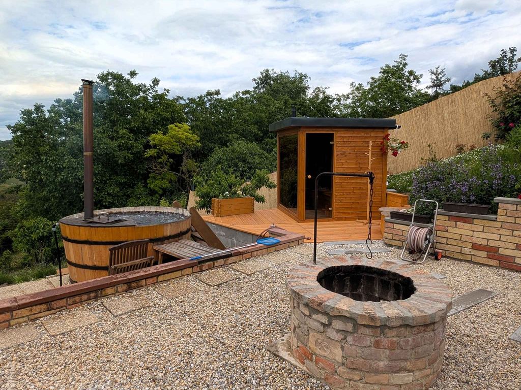 Ferienhaus in einer malerischen Landschaft, Holzfass mit Whirlpool und Sauna