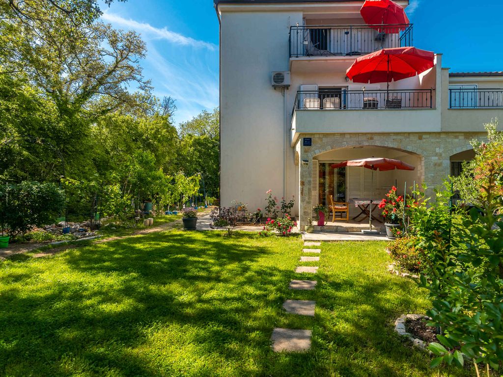 Ferienwohnung mit Klimaanlage und Grill, umgeben von Grün