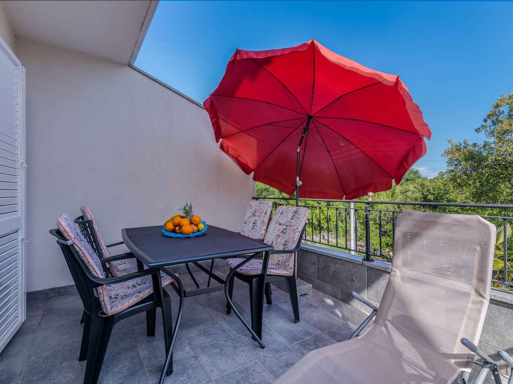 Ferienwohnung mit Klimaanlage und Grill, umgeben von Grün