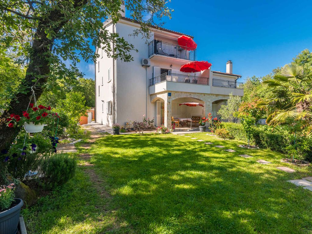 Ferienwohnung mit Klimaanlage und Grill, umgeben von Grün