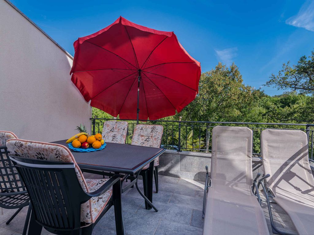 Ferienwohnung mit Klimaanlage und Grill, umgeben von Grün