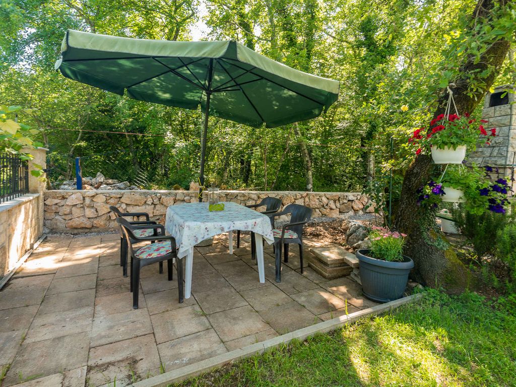 Ferienwohnung mit Klimaanlage und Grill, umgeben von Grün