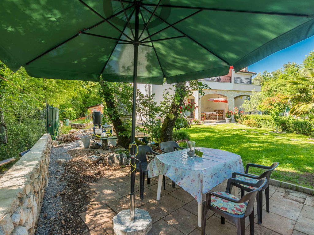 Ferienwohnung mit Klimaanlage und Grill, umgeben von Grün