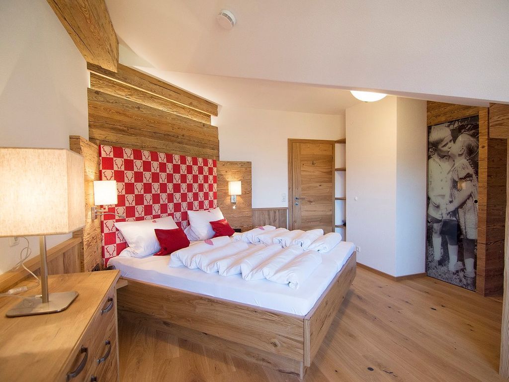 Alpenländischer Luxus im Stadl-Stil mit Massivholzbett und begehbarem Kleiderschrank. Hier lässt es sich herrlich träumen!