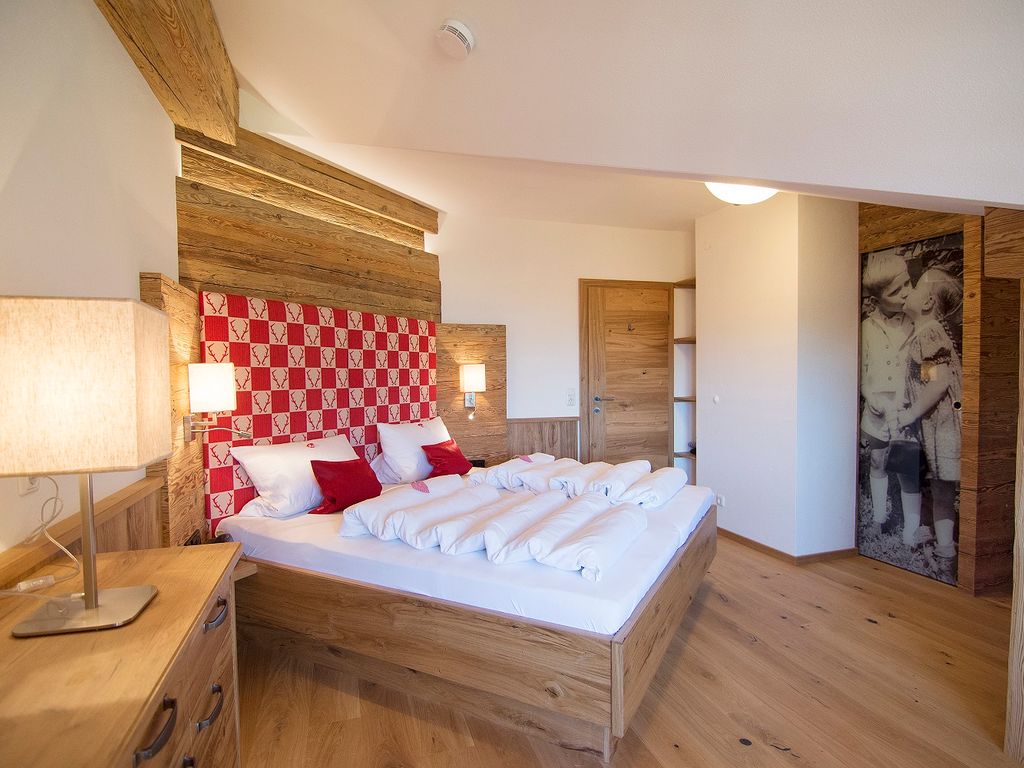 Alpenländischer Luxus im Stadl-Stil mit Massivholzbett und begehbarem Kleiderschrank. Hier lässt es sich herrlich träumen!