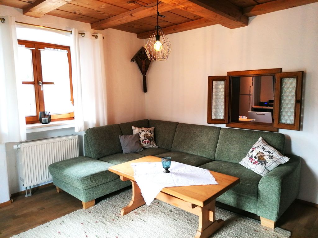 Wohnzimmer mit Couchecke und "Guckerl" in die Küche