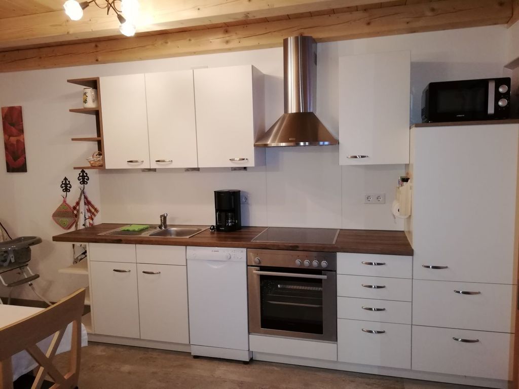 Küche mit Essecke und Zugang zum überdachten Balkon