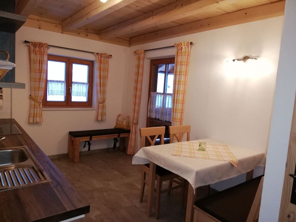 Küche mit Essecke und Zugang zum überdachten Balkon