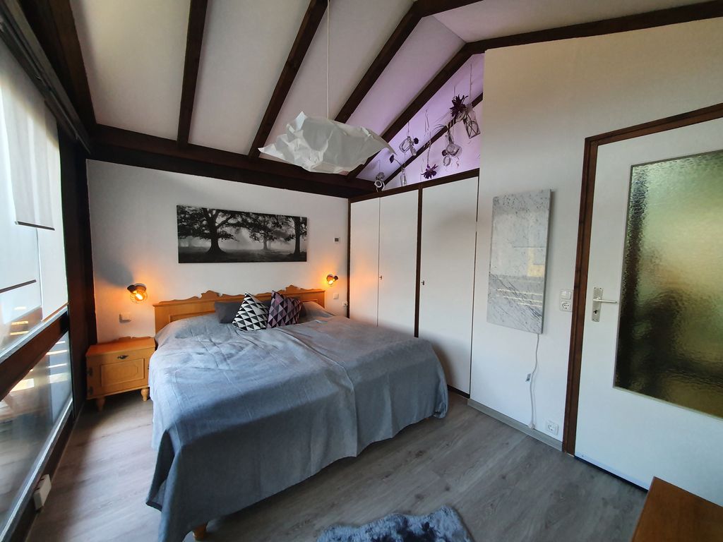 Schlafzimmer mit Doppelbett und Zugang zu oberem Balkon