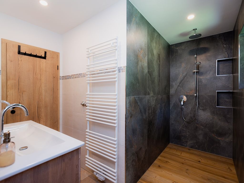 Badezimmer mit großer Regendusche und zwei Fenstern